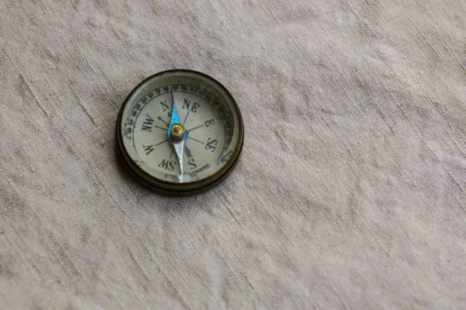 Round compass on a flat surface covered with canvass